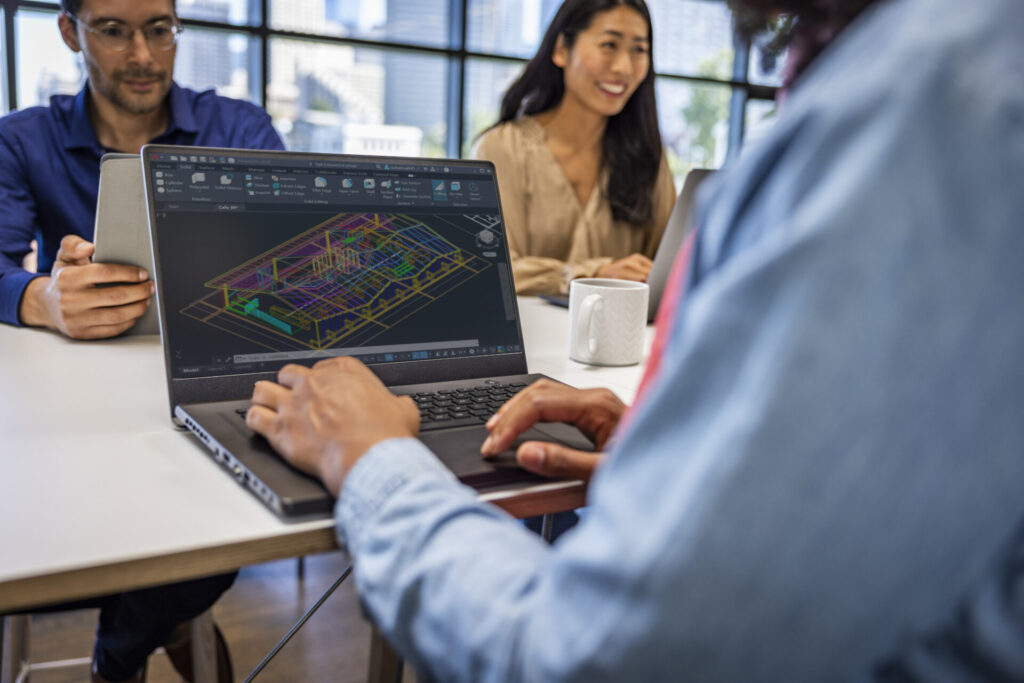 People in a meeting using AutoCAD on laptop