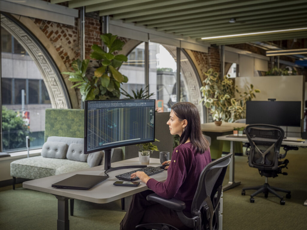Woman using AutoCAD in an office environment.