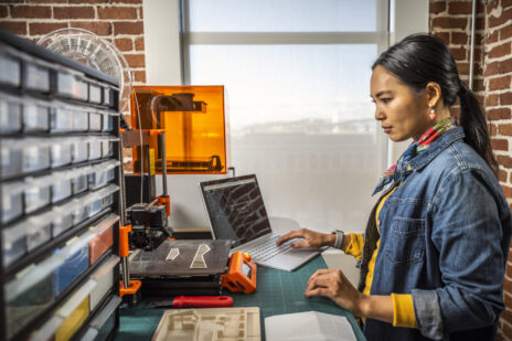 Woman using AutoCAD in a maker space environment.