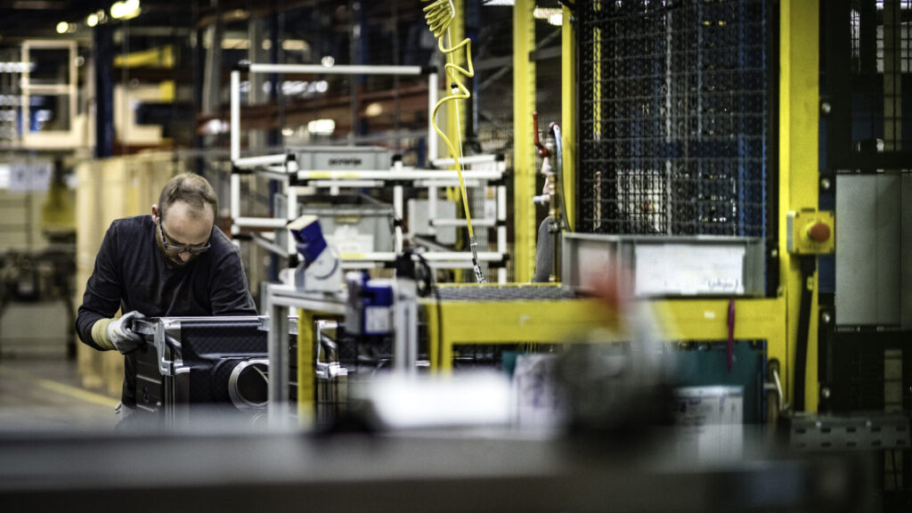 Man assembling a washing machine using JIT manufacturing principles.