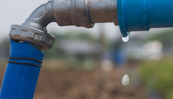 a drop of water leaking from a pipe connection